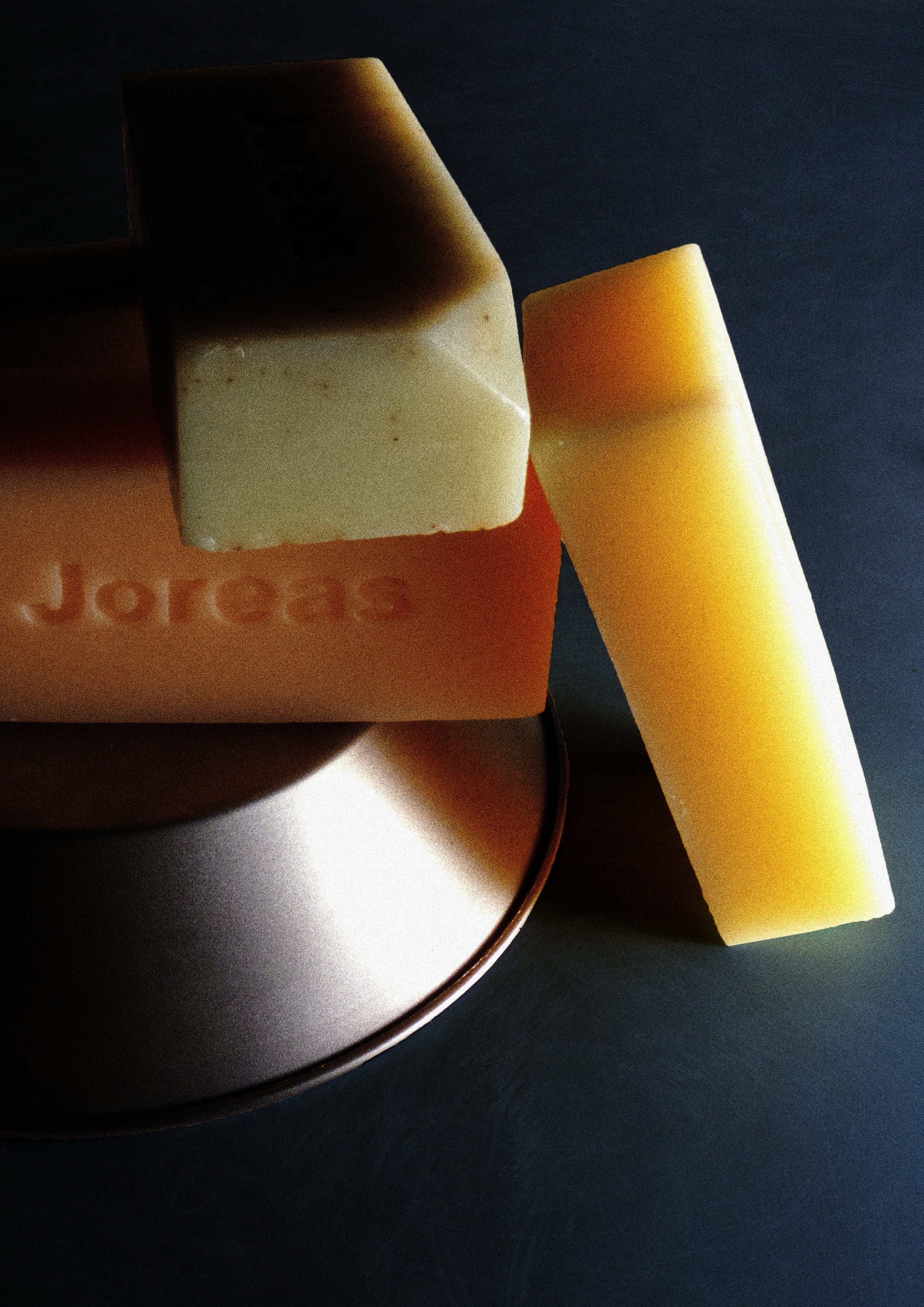 Assorted artisanal cleansing soap bars with engraved text on a dark background