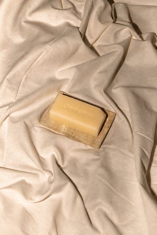 Cherish Milk Bar and natural stone soap dish set styled on beige fabric