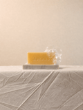 Cherish Milk Bar displayed on a minimalist natural stone soap dish