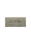 Natural exfoliating soap bar with subtle speckled texture, embossed with brand name