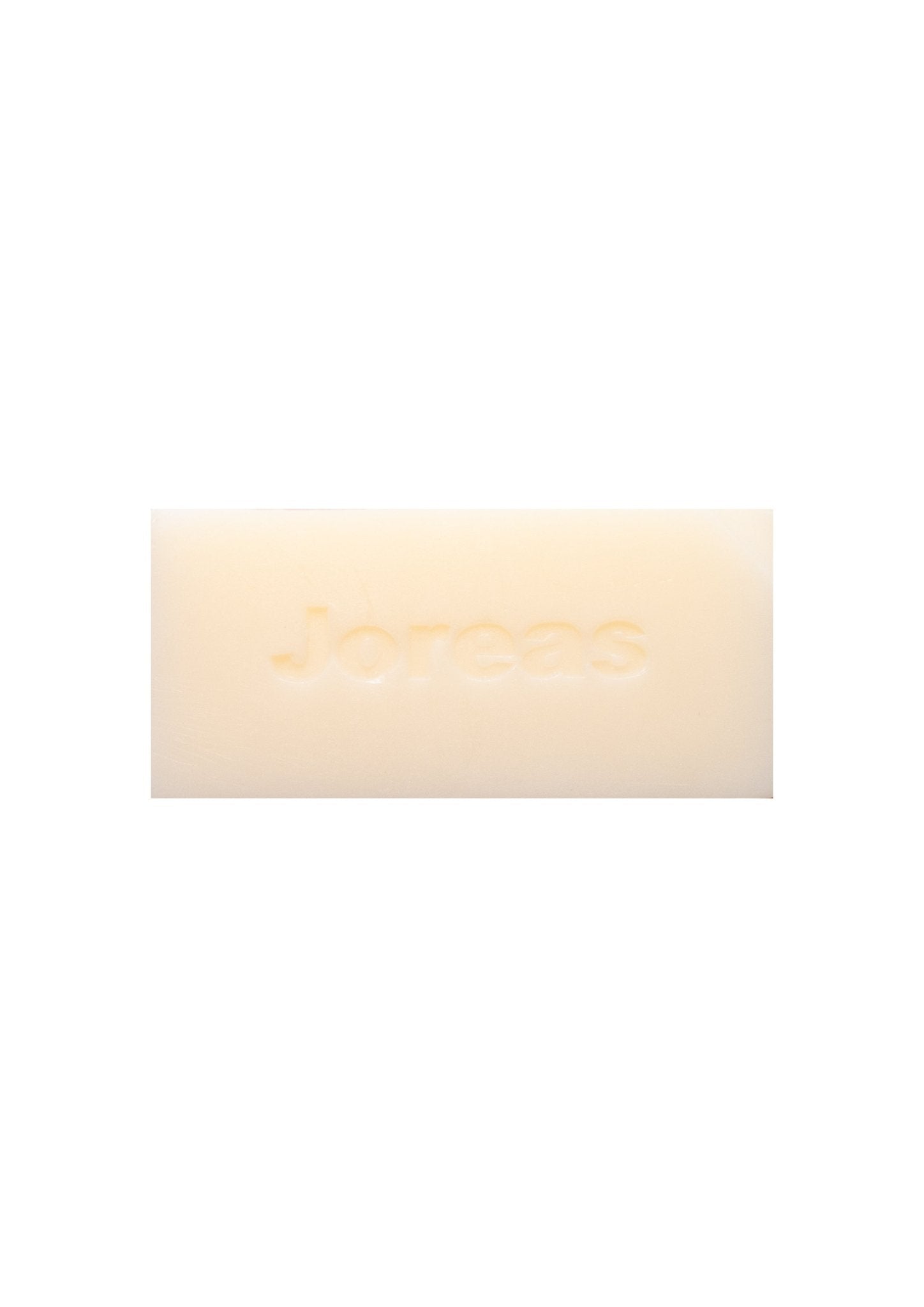 Creamy rectangular cleansing bar with embossed text on a white background